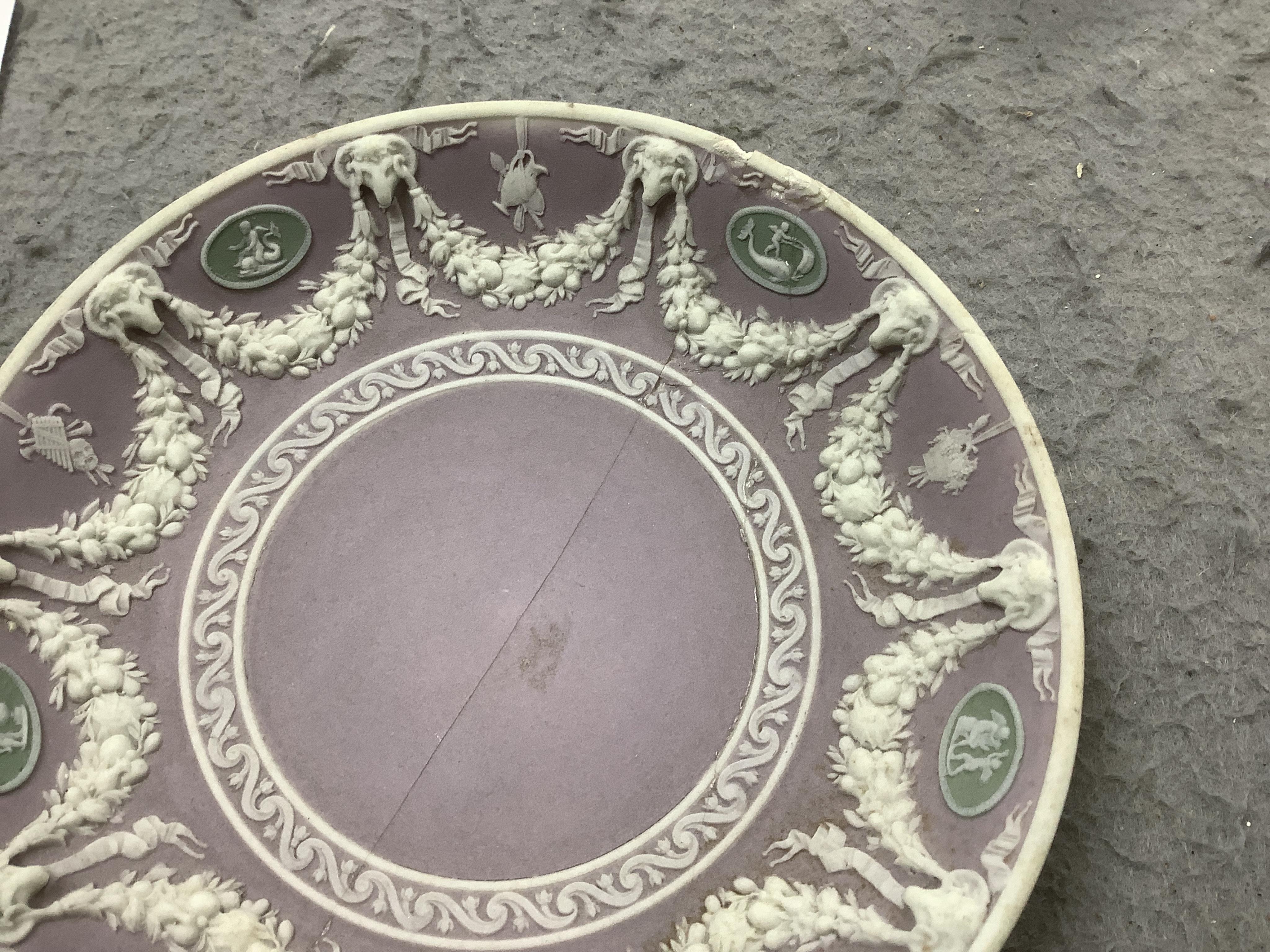 A Wedgwood three colour, green ground jasper cup and saucer and a single lilac ground saucer, early 19th century, 13.5cm. Condition - poor